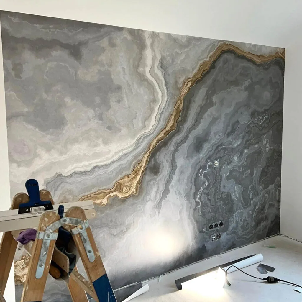 Moderne graue Wand mit goldenen Akzenten.