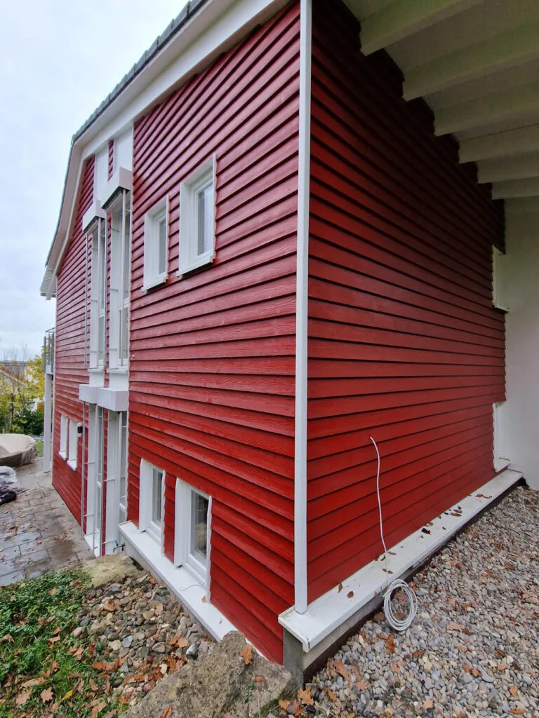 Modernes rotes Holzhaus mit Fenstern