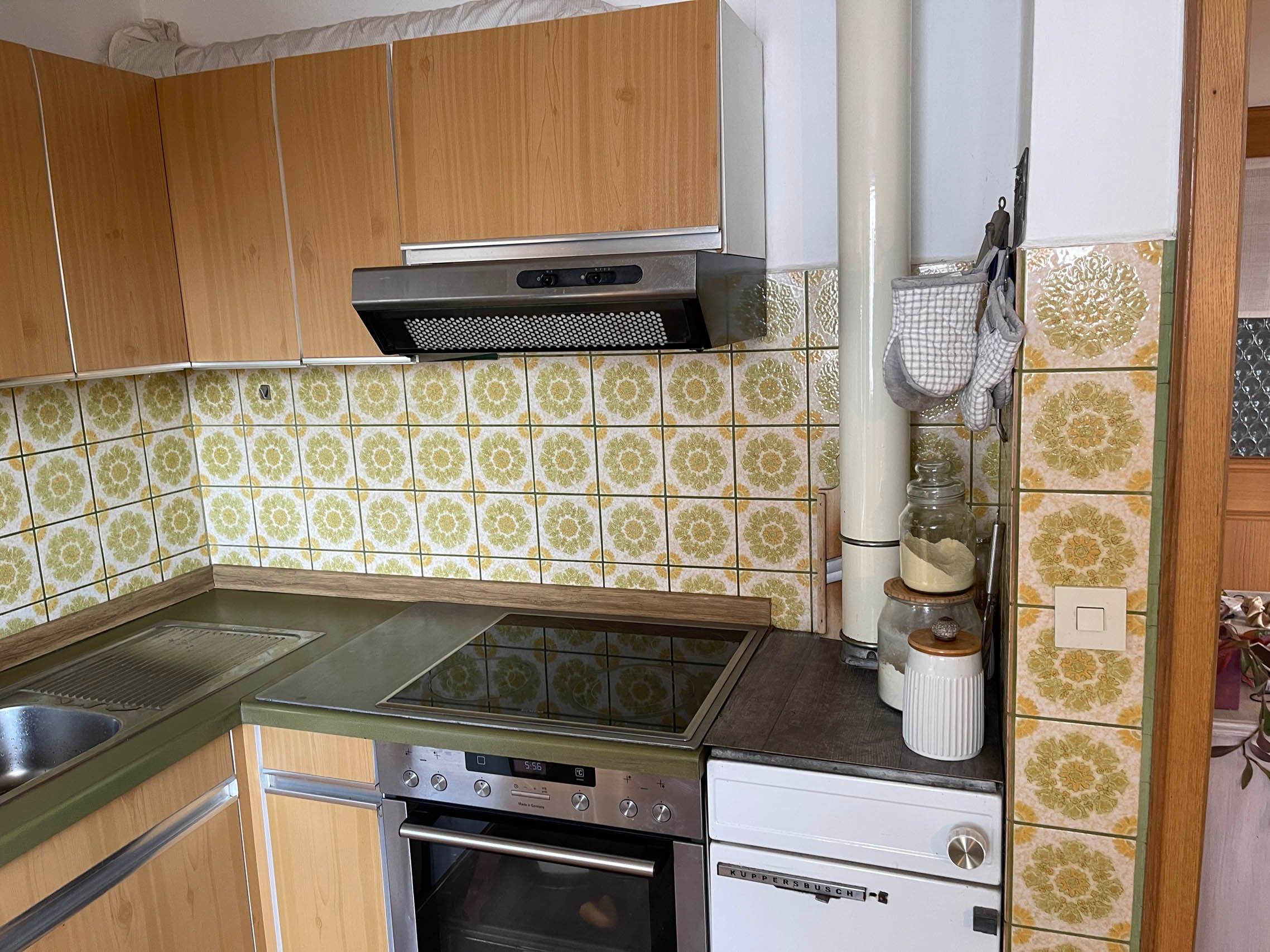 Moderne Küche mit grünem Herd und blumigen Fliesen